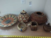 All six baskets arranged on surface with measuring tape for scale
