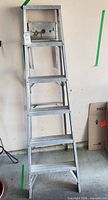 Full view of aluminum 5-step ladder standing folded