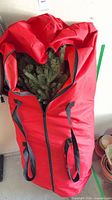 Tree branches visible inside red zippered storage bag
