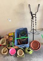 Group of assorted pots stacked, blue storage bin, wrought iron stand