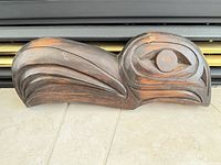 Front of dark carved wood bird head plaque