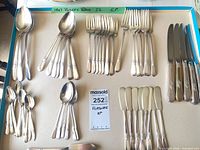 Tray showing grouped flatware pieces including spoons, forks, knives and butter spreaders
