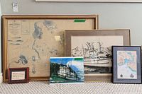 Group shot of five framed maritime pieces leaning against wall