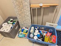 Overall lot showing tote, laundry basket, ironing board, drying rack and visible cleaning supplies