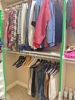 Closet view showing shirts on upper rod and pants on lower rod