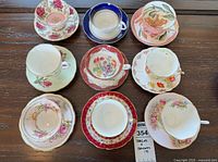 Top-down view of nine teacup and saucer sets arranged in three rows
