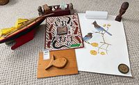 Group shot showing all major items: sailboat, Aboriginal panel, bird print, fish plaque, wood bust, small carvings and trinkets