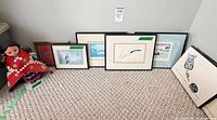 Group view of six framed prints and doll