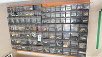 Full view of wall-mounted organizer showing rows of clear-front bins with contents
