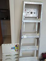 Front view of aluminum ladder and folded step stool