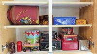 Group shot of all tins on two cabinet shelves