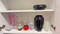 Shelf with mixed vases and glassware showing quantity, colors and forms