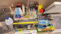 Countertop view showing all bulb boxes, cleaning supplies, hardware