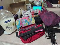 Overview of toiletry bags, soap bottle, hair dryer and assorted accessories