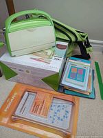 Full lot showing Cuttlebug machine, carry bag, Fiskars trimmer, embossing folders, original box