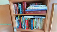 Two-shelf cabinet with assorted reference, history and fiction books; shows formats and volume count
