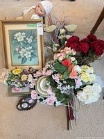 Group shot showing framed print, cross-stitch frames, baby doll and artificial flower stems