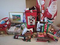 Overall lot with large blow-mold Santa, wooden Santa board, framed prints, wrapping paper, fabric items and ornaments
