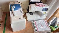Main machine with cover, manuals, boxed presser feet visible
