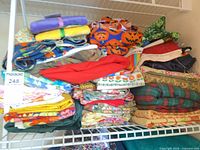 Shelf holding multiple stacks of assorted folded quilting fabrics