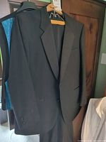 Black tuxedo jacket and pants hanging