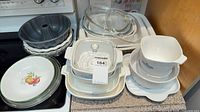 Overall lot on stovetop: CorningWare casseroles & bowls, Bundt pans, Corelle bowls