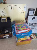 Overall view showing wooden peg board, stack of boxed puzzles/games, boxed card shuffler