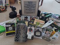Group shot of all items spread on floor showing headcover, glove, statue, needlepoint, books, accessories.
