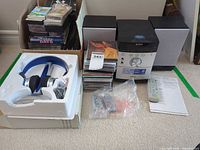 Entire lot: main unit, two speakers, headphones in styrofoam, box and stack of CDs, remote, paperwork