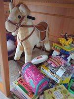 Side view of rocking horse, books, TipOver game, puzzle pieces, plush toys