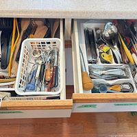 overview of two kitchen drawers filled with assorted utensils and flatware