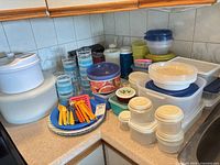 full lot overview showing assorted containers, bowls, tumblers, plates, utensils