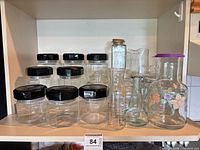 Full lot showing jars with black lids, swing-top bottles, embossed bottle and floral carafe