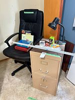Overall view showing chair, filing cabinet, lamp, ruler and supplies