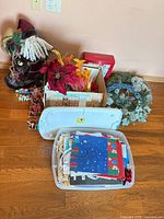 Group shot showing Santa figurine, wreath, poinsettias, storage tote with gift bags, wrapping paper rolls and small gift boxes