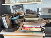 Overall lot showing cookware, bakeware, utensils and books