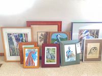Group shot of all nine framed artworks leaning against wall
