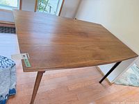 Angled view of table showing top surface and tapered legs