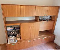 Front view of full teak wall unit showing cabinets, shelves, bar section