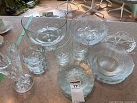 Group shot of all clear pressed glass items on counter