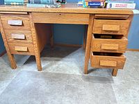 front view of oak desk showing drawer arrangement and light oak finish