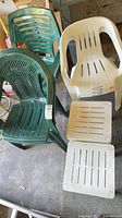 Group of two green chairs, one white chair, and three white stools