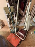 Group shot of vacuum, carpet sweeper, floor polisher, ladder