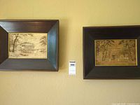 Both framed textile artworks on wall
