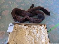 Full view of brown mink fur stole coiled on surface