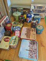 Full lot showing varied tins arranged on floor