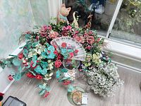Overview showing artificial flowers, vases, wooden figurines, fan