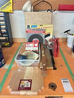 Entire lot arranged on bench showing all accessories, abrasives, hole saw, clock blank, mounting jig