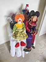 Overall lot: three large dolls/puppets, hatbox with small dolls on skirted side table
