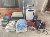 Group shot showing towels, sheets, air purifiers, commode, radio, hot water bottle, IV stand